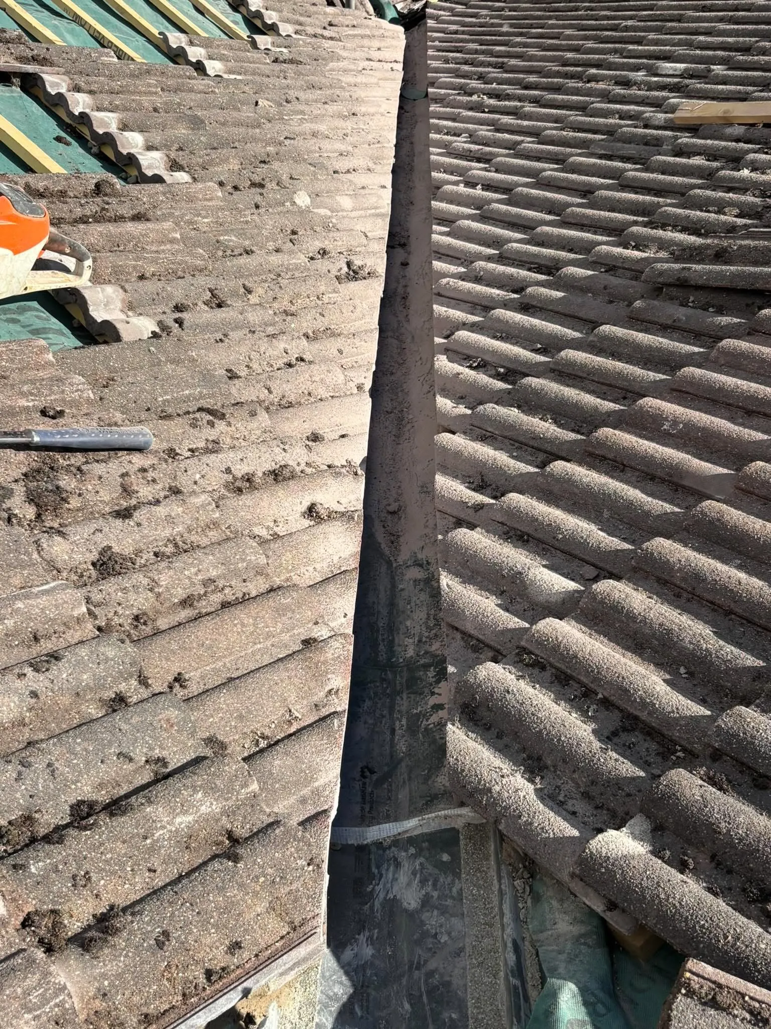 Roof valley renewal in progress with new valley trough and cut-back tiles